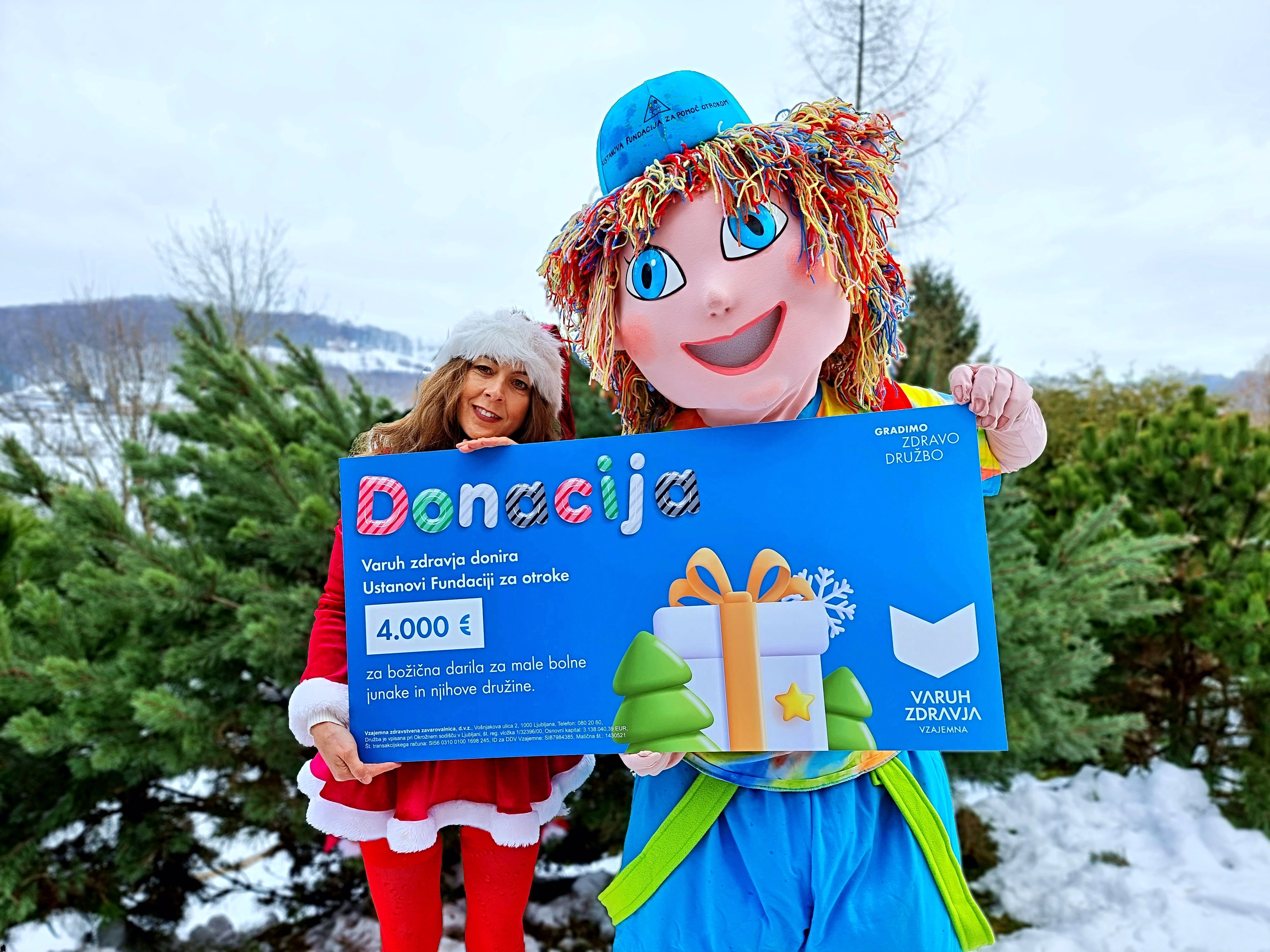 Olga Bahun Jakelj Z Maskoto Ustanove Fundacije Za Otroke Malim Junakom Ob Prejemu Praznicne Donacije Varuha Zdravja Vzajemne